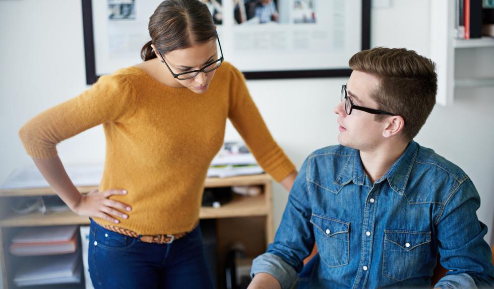 Å be om hjelp på jobben. Illustrasjonsbilde av to personer på et kontor.